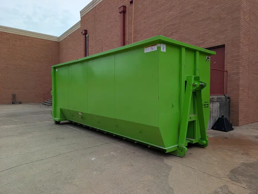 Tall 30-yard roll-off dumpster beside a commercial building